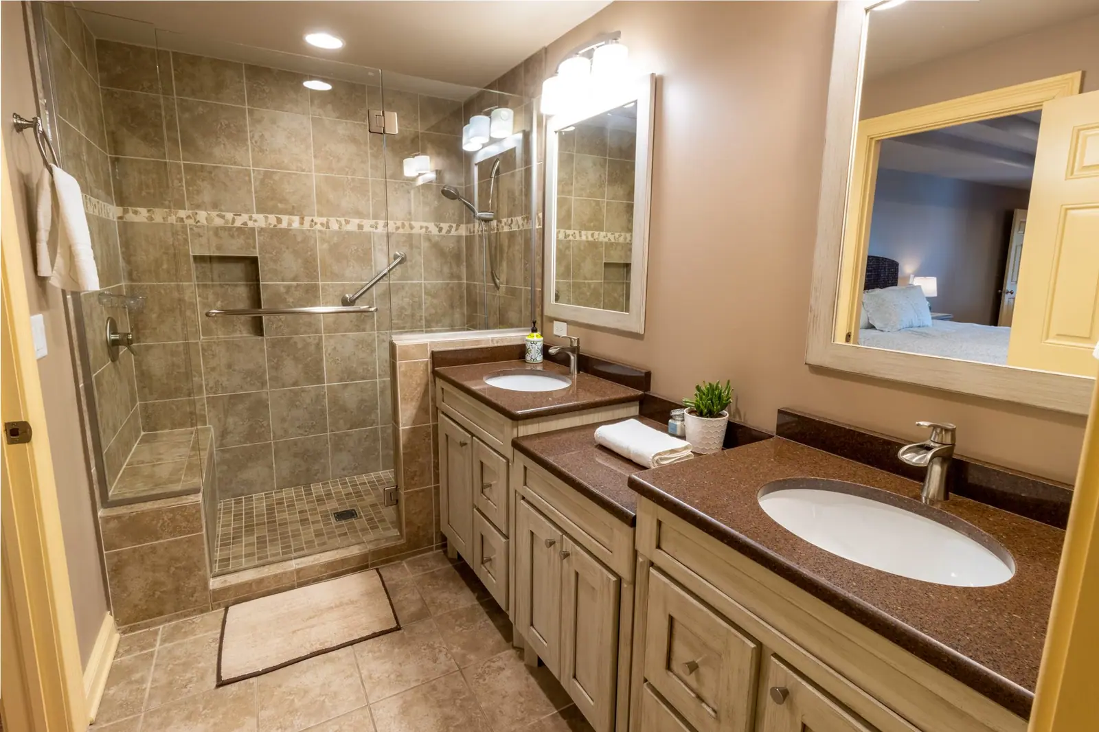 First-floor master bathroom with a tiled walk-in shower and double vanity