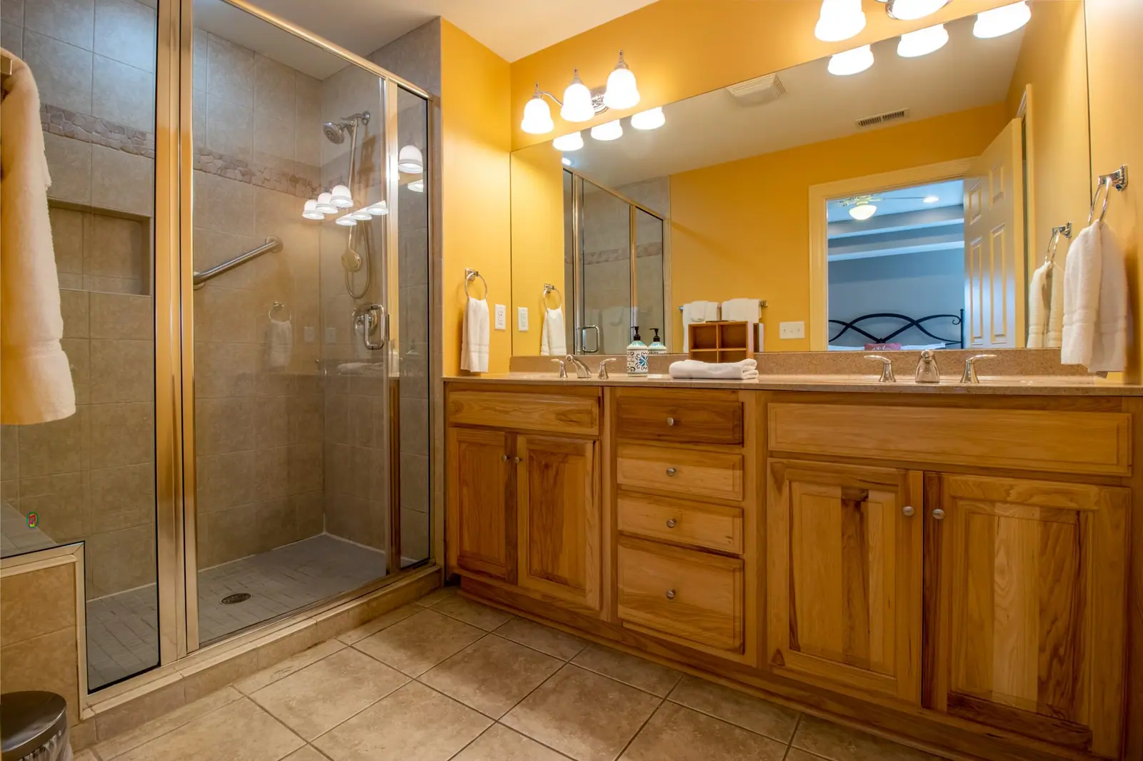 Upstairs master bathroom with a glass walk-in shower and wood double vanity