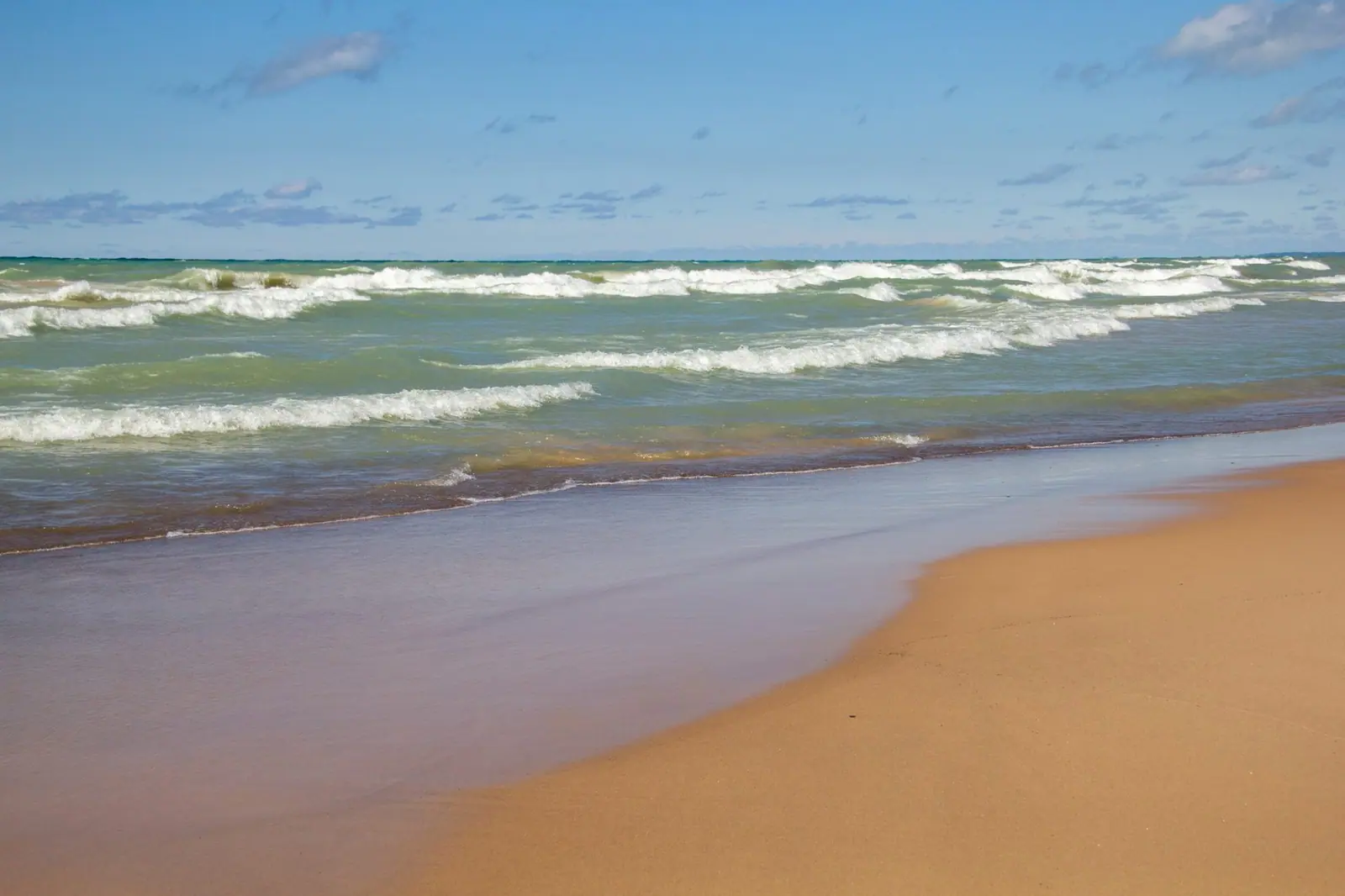 Lake Michigan waves rolling onto a wide sandy beach near Michigan City