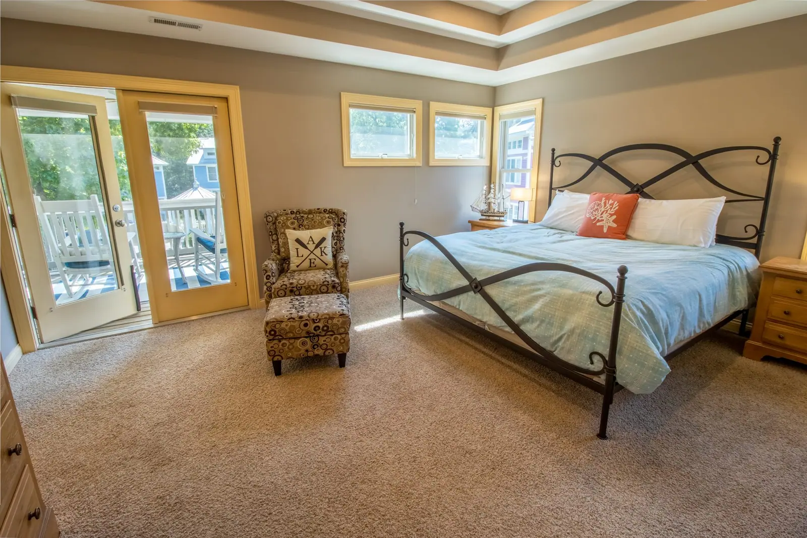 Upstairs master bedroom with an iron king bed and French doors to a screened porch