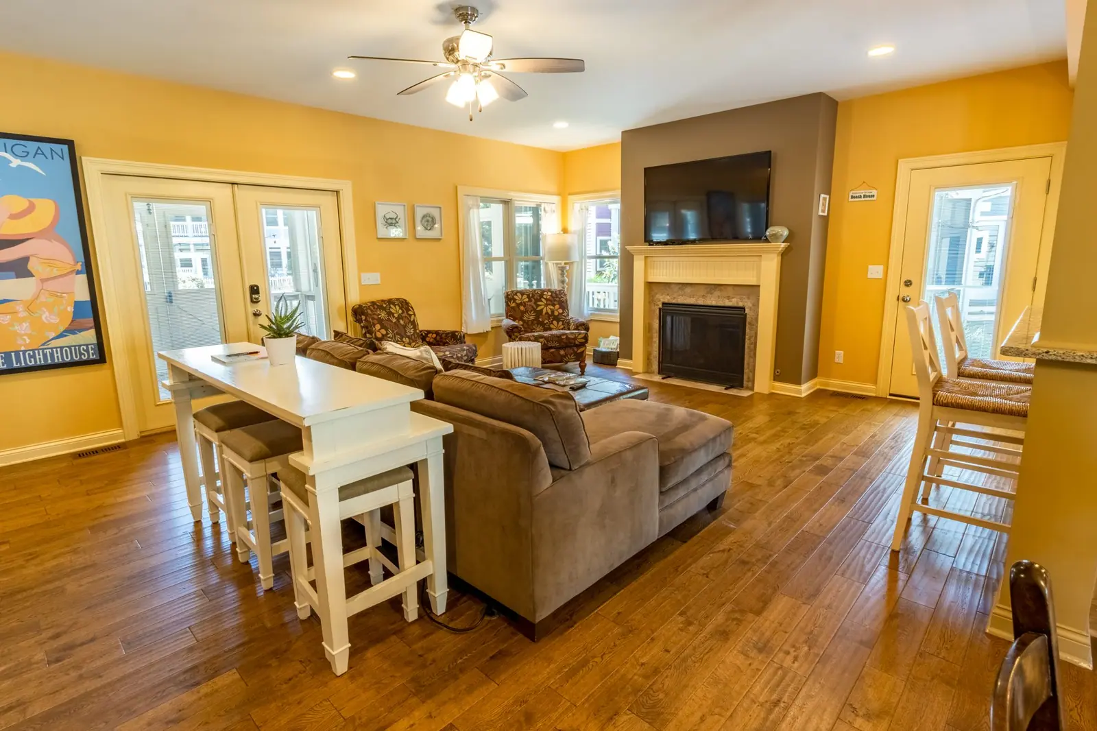 Living room with fireplace and TV next to the bar table and kitchen