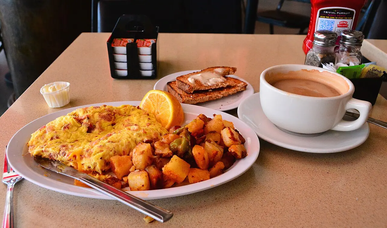 A diner breakfast of omelet, home fries, toast and coffee
