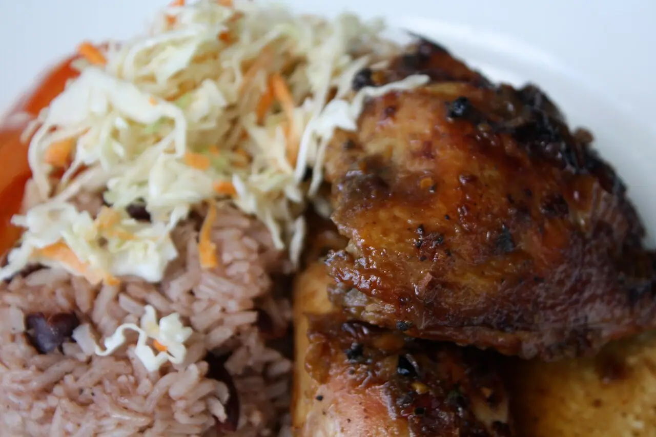 A Jamaican jerk chicken plate with rice and peas and slaw