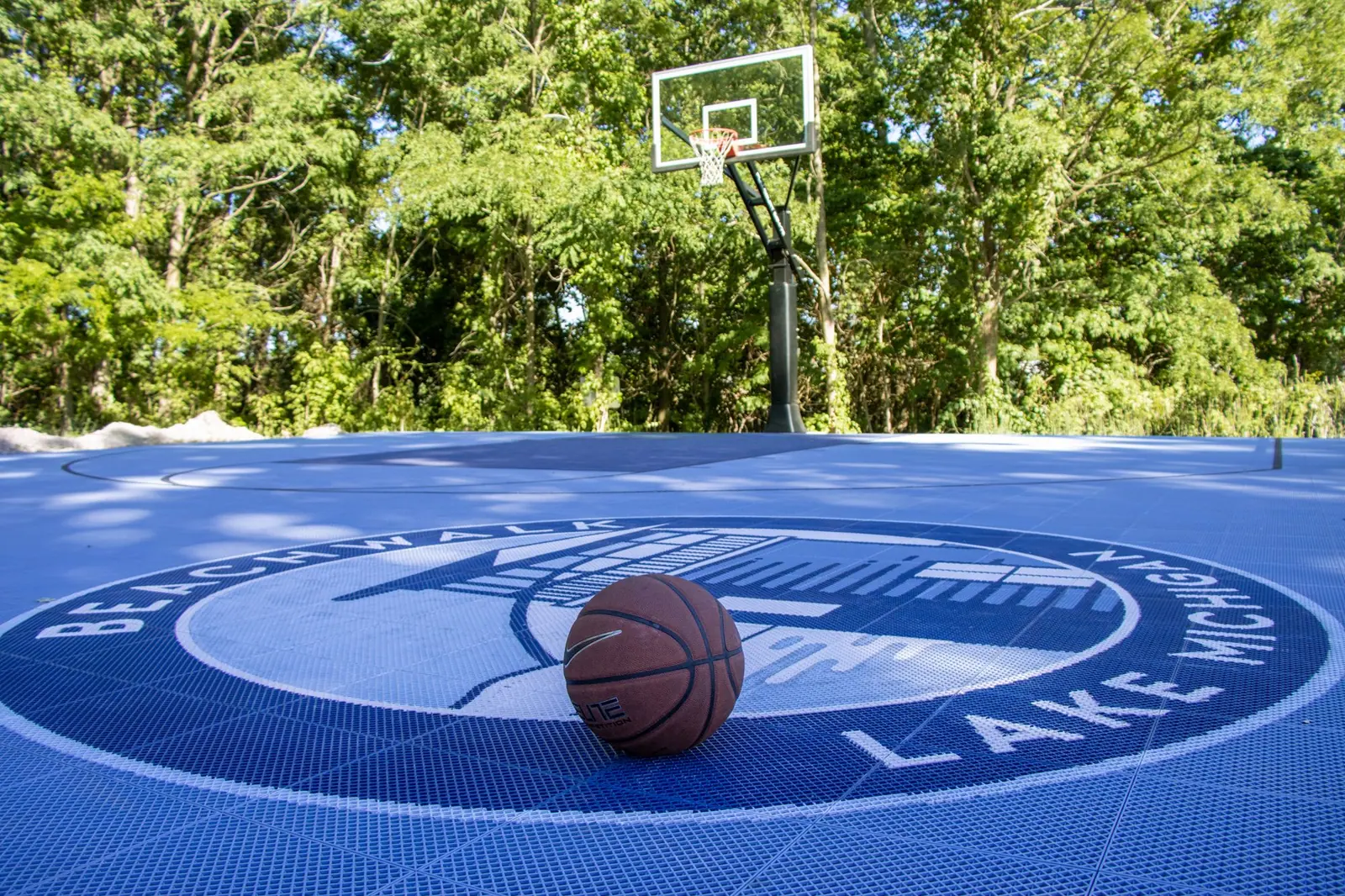Basketball resting on the blue Beachwalk court under a hoop