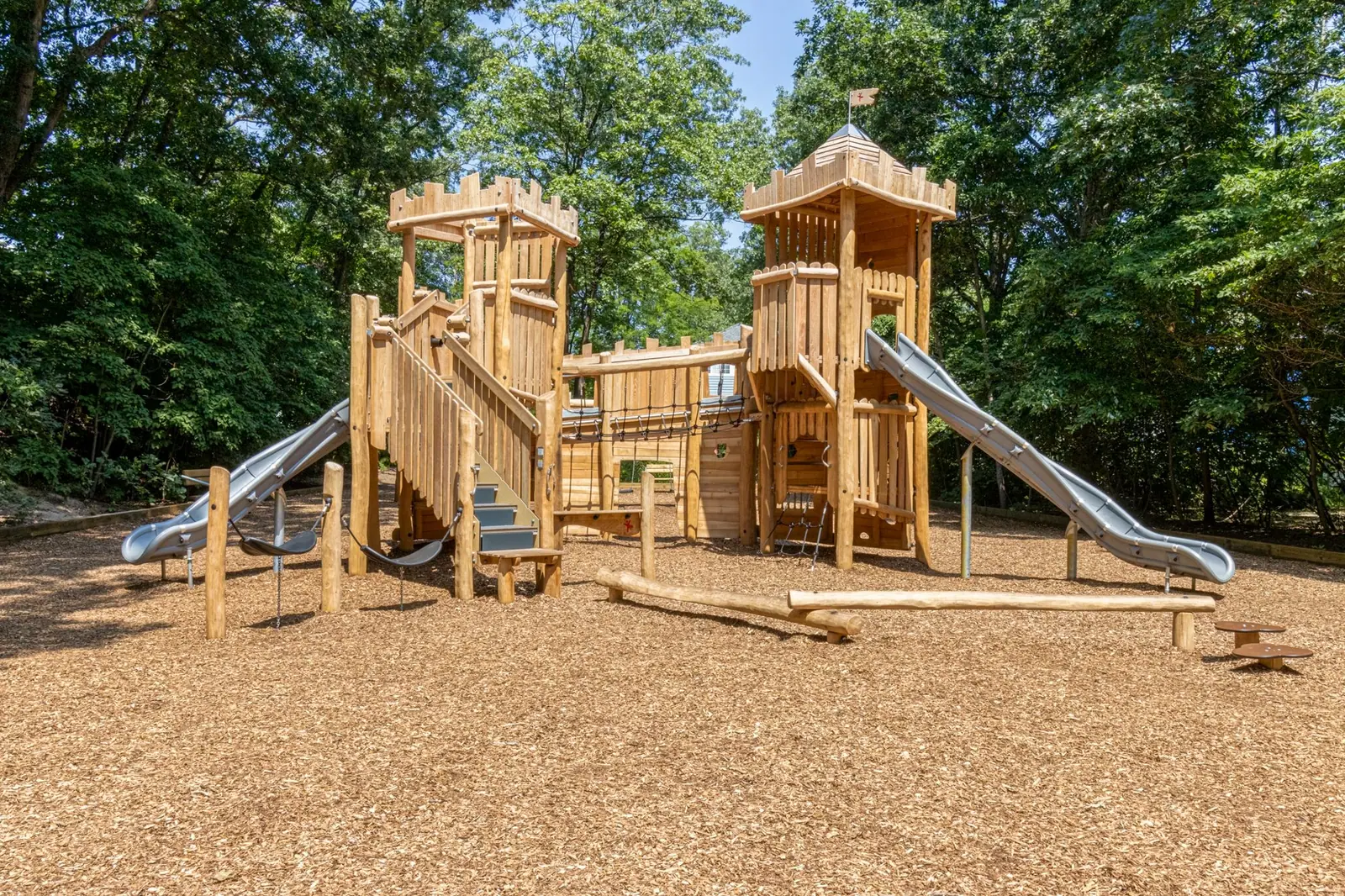 Wooden castle-style playground with two slides