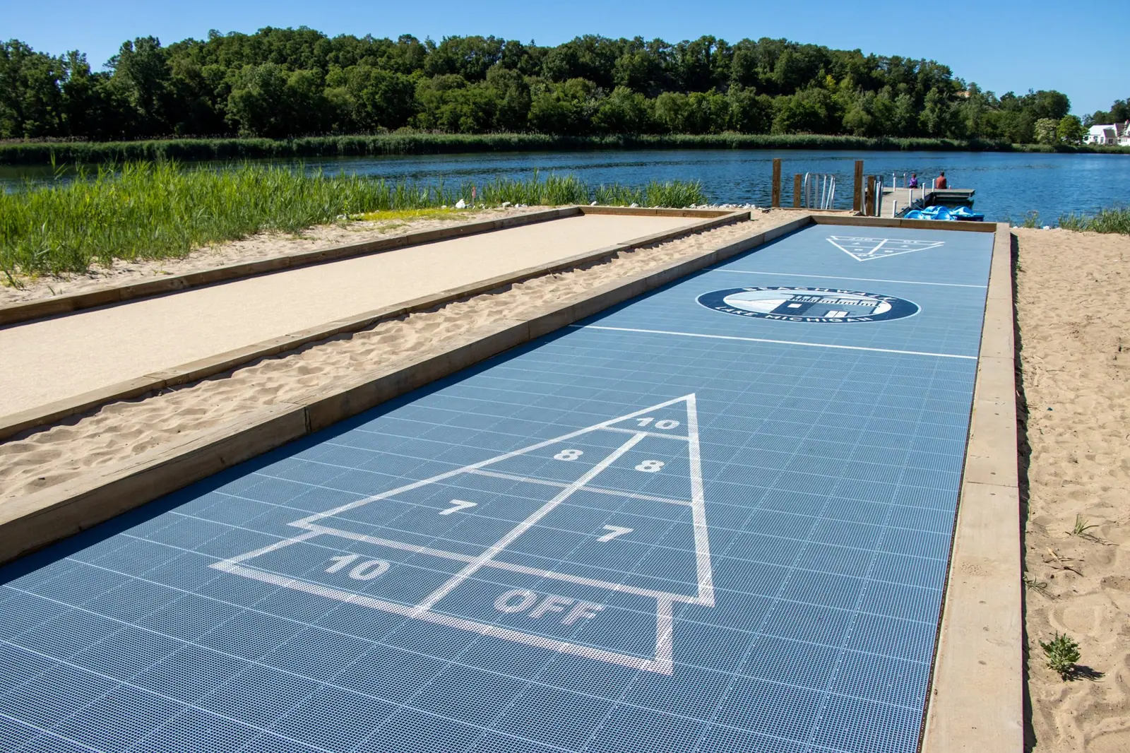 Blue shuffleboard court beside the lake
